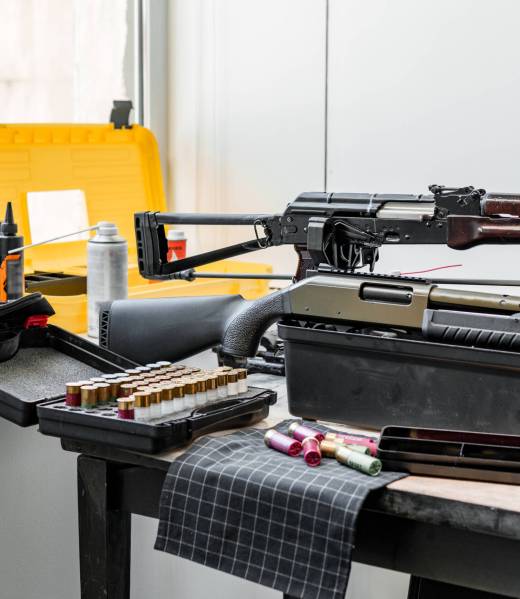 Shotgun rifle with cartridges on table in a weapon workshop Shotgun rifle with cartridges on table in a weapon workshop close up